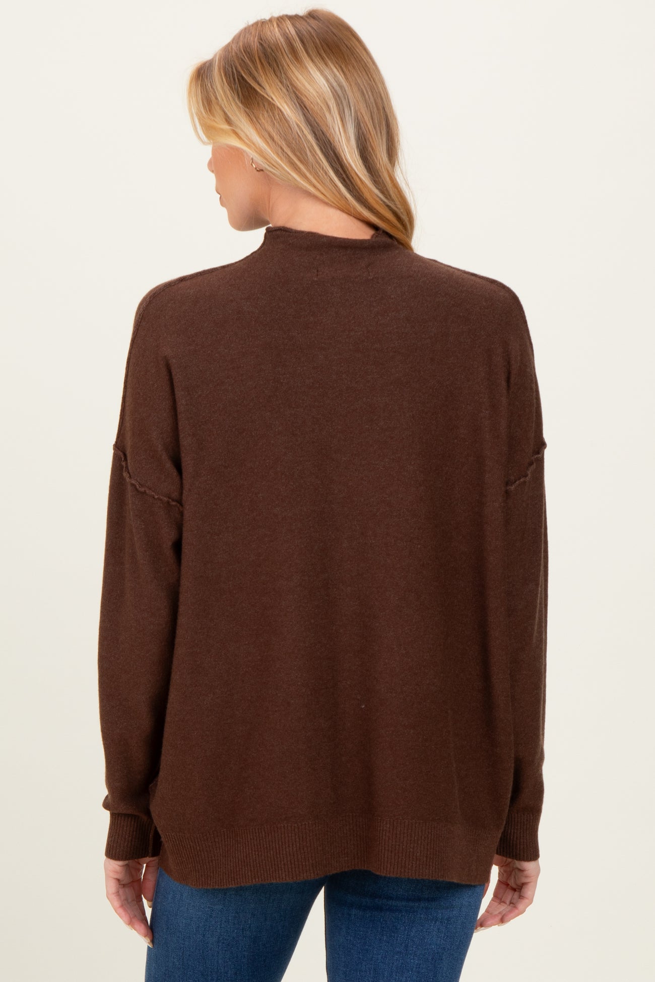 woman wearing a brown oversized maternity sweater viewed from the back, with long sleeves and a relaxed fit