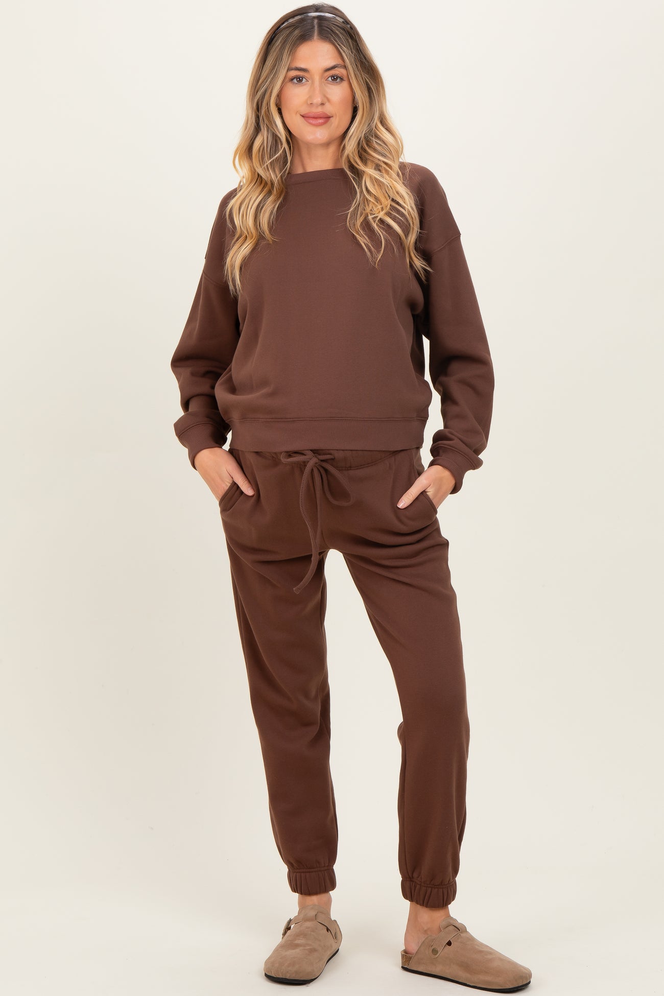 woman wearing a chocolate brown maternity sweatshirt and matching joggers with a relaxed fit and pockets