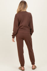 woman wearing a brown maternity sweatshirt and matching joggers, showing the back view with a relaxed fit