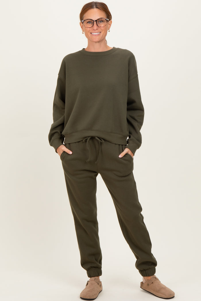 woman wearing an olive green sweatshirt and matching jogger pants with a drawstring waist and side pockets