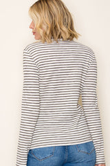woman wearing a striped long sleeve top, seen from the back, paired with blue jeans