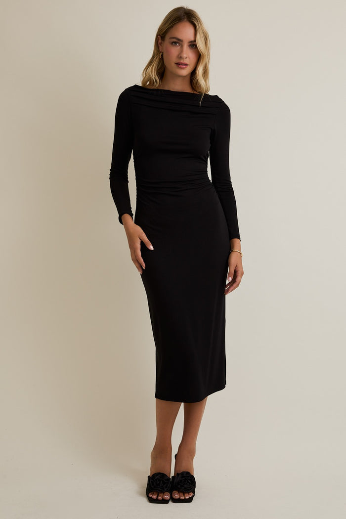 woman wearing a black long sleeve fitted midi dress with a draped neckline and styled with black slide sandals