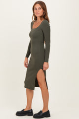 woman wearing an olive green ribbed midi dress with long sleeves and a side slit, paired with black platform shoes
