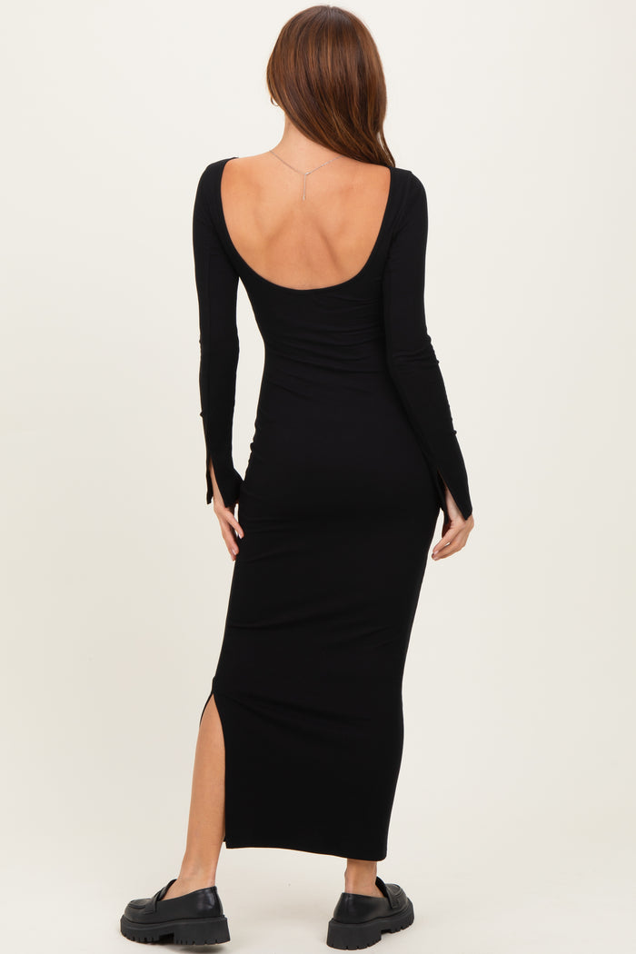 woman wearing a black long sleeve ribbed maxi dress with a deep back and side slit, standing against a neutral background