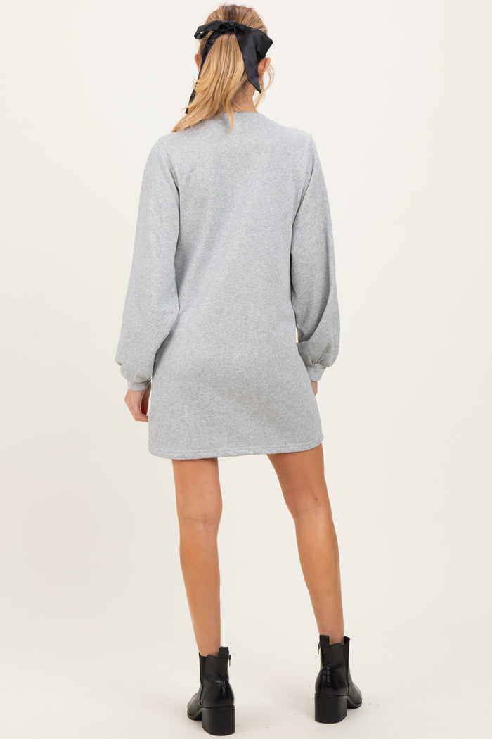 woman wearing a grey long sleeve maternity dress with a relaxed fit and balloon sleeves, showing the back view