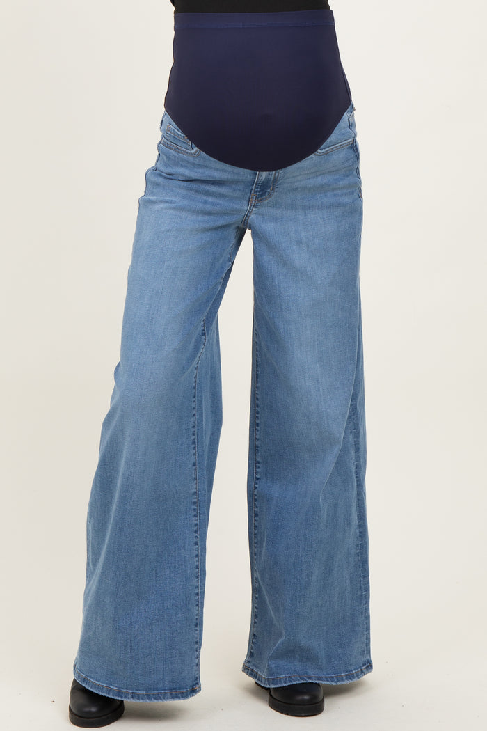 woman wearing a pair of light blue wide-leg maternity jeans with a dark blue over-the-bump panel