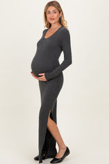woman wearing a grey ribbed maternity maxi dress with side slits and holding her baby bump