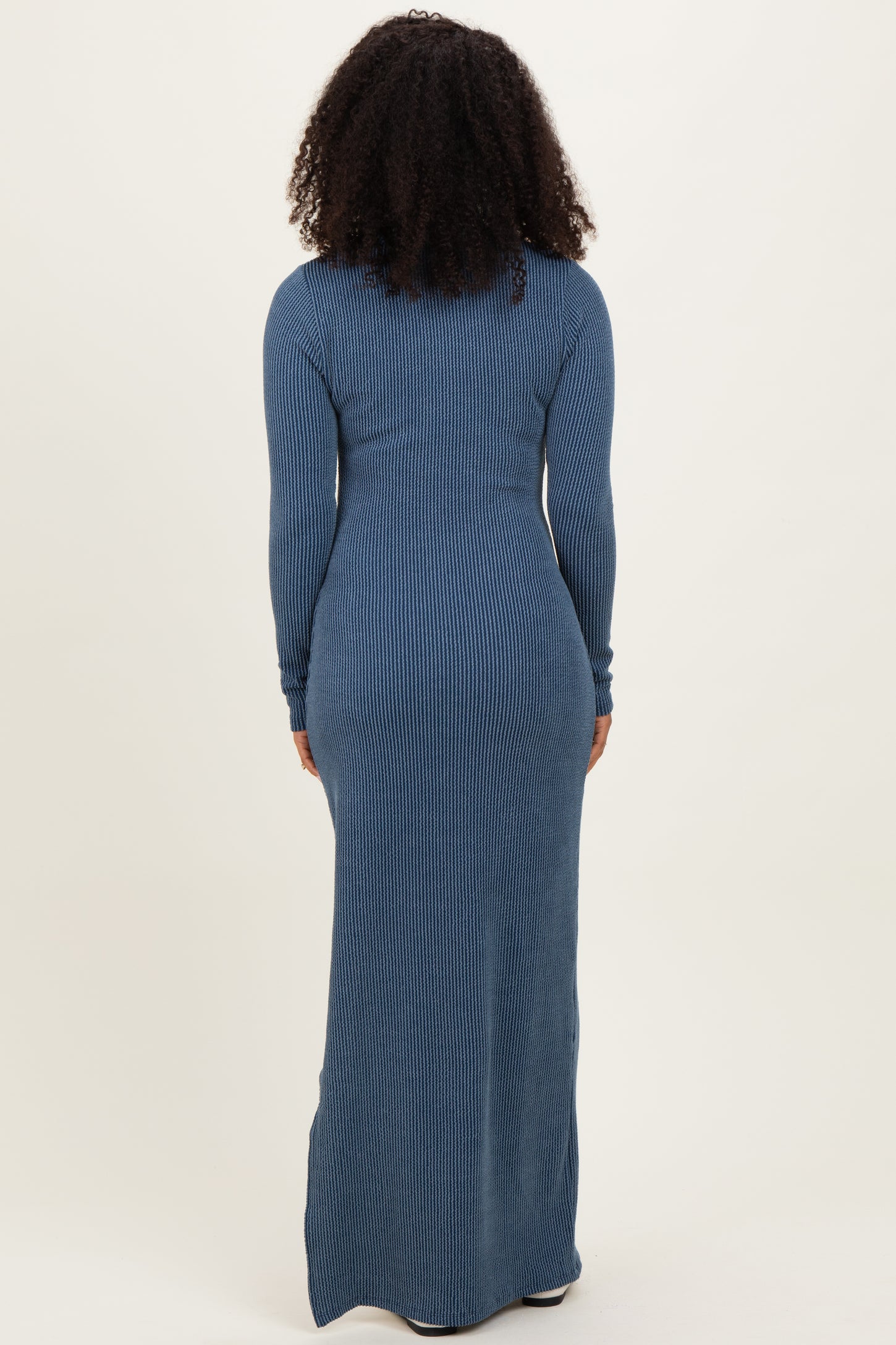 woman wearing a long sleeve ribbed maxi dress in blue, seen from the back