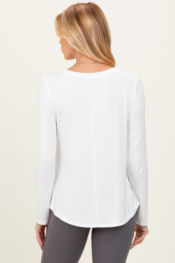 woman wearing a white long sleeve maternity top, shown from the back with a relaxed fit and curved hem
