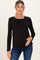 woman wearing a black long sleeve maternity top and gently holding her baby bump