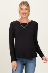 woman wearing a black long sleeve maternity top with a relaxed fit and smiling at the camera