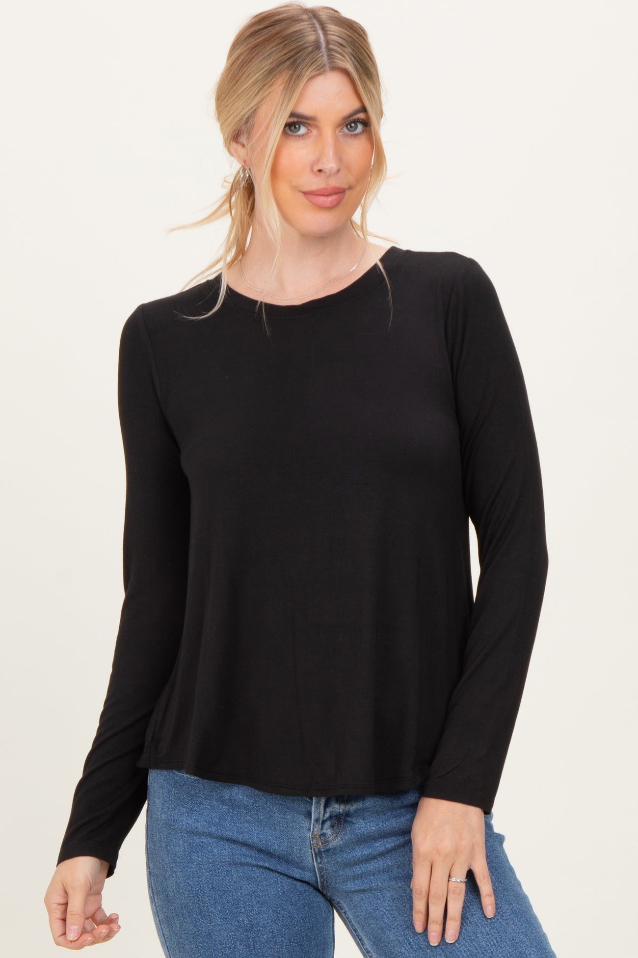 woman wearing a black long sleeve top and blue jeans