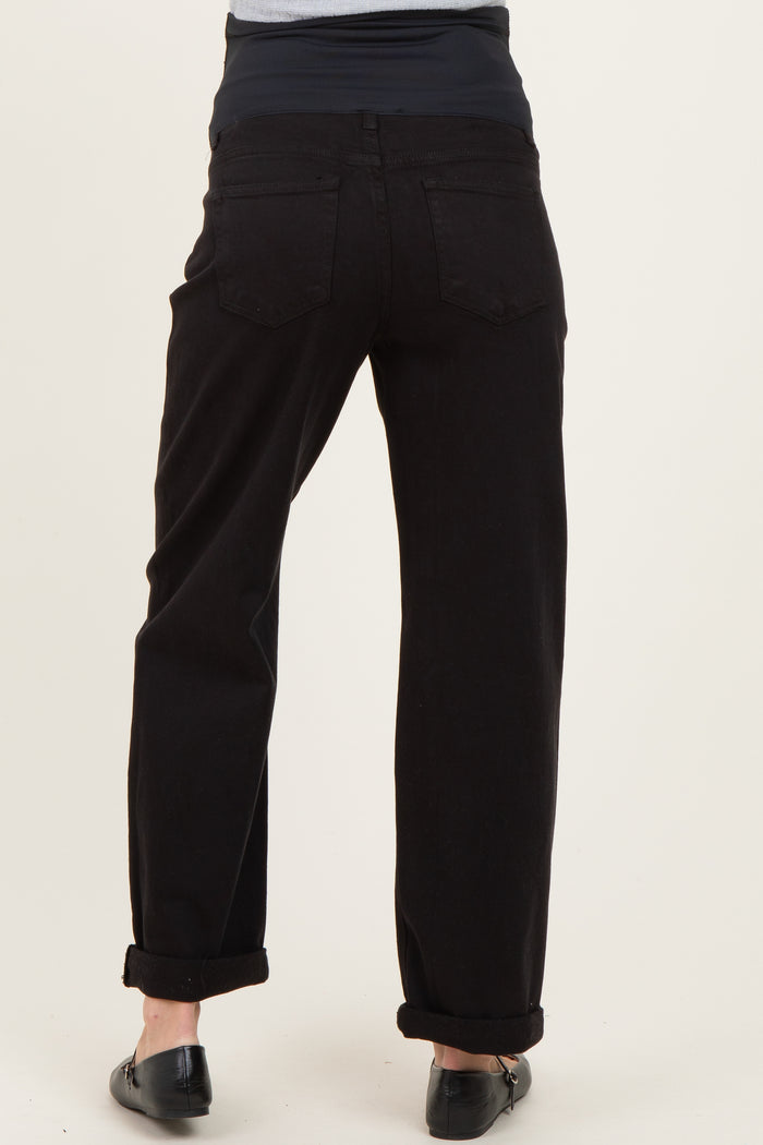 woman wearing black maternity jeans with a rolled hem and a stretchy navy waistband, showing the back view