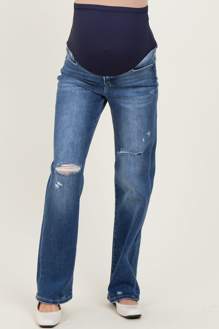 woman wearing distressed blue maternity jeans with a navy belly panel and flared leg style