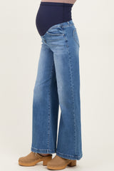 woman wearing light blue wide-leg maternity jeans with a navy underbelly support panel and a visible baby bump