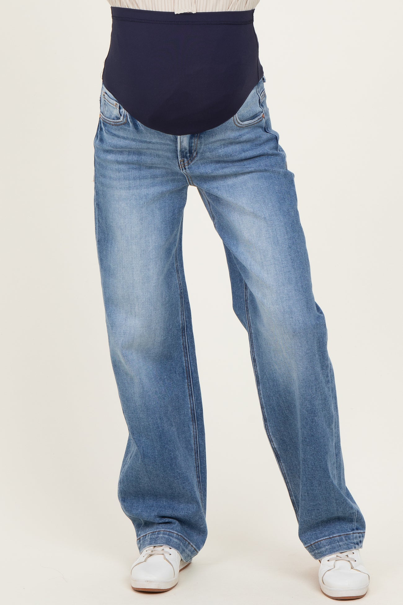 woman wearing blue maternity jeans with a navy belly panel and a relaxed fit