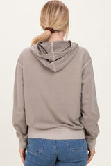 woman wearing a gray oversized hoodie with a drawstring and back detailing, styled with blue jeans