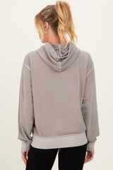 woman wearing a gray maternity hoodie with a relaxed fit and a hood, showing the back view