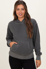woman wearing a gray maternity hoodie with a front pocket and long sleeves, styled with black leggings