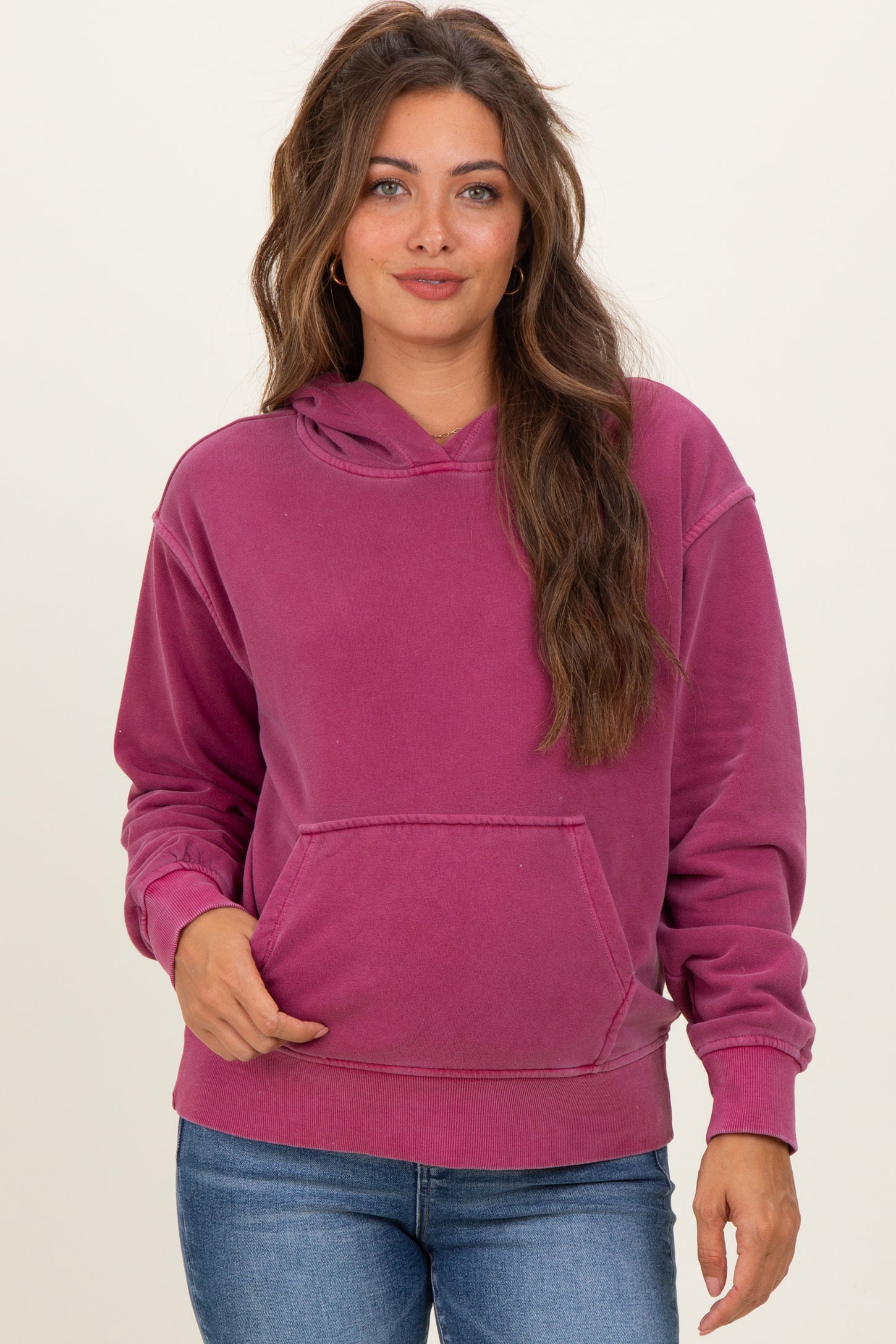 woman wearing a purple maternity hoodie with a front pocket and adjustable hood, styled with blue jeans