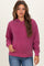 woman wearing a purple maternity hoodie with a front pocket and adjustable hood, styled with blue jeans