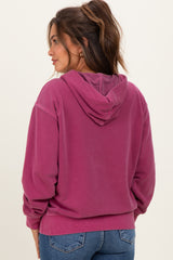 woman wearing a pink maternity hoodie with a hood and relaxed fit, seen from the back