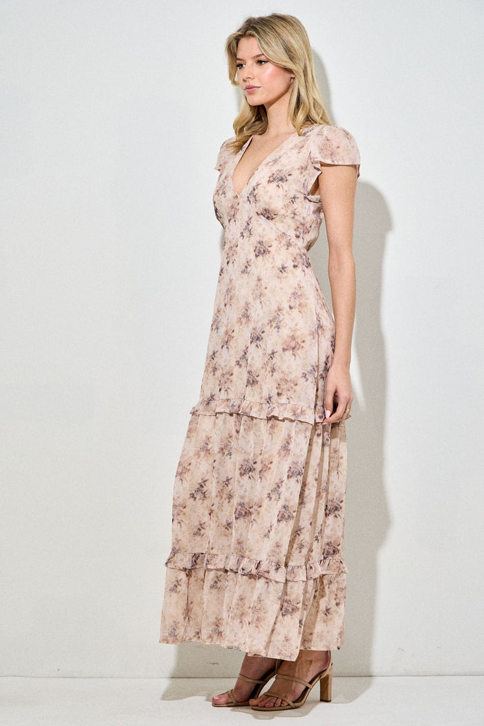 woman wearing a floral print maxi dress with ruffle sleeves and tiers, styled with beige heels
