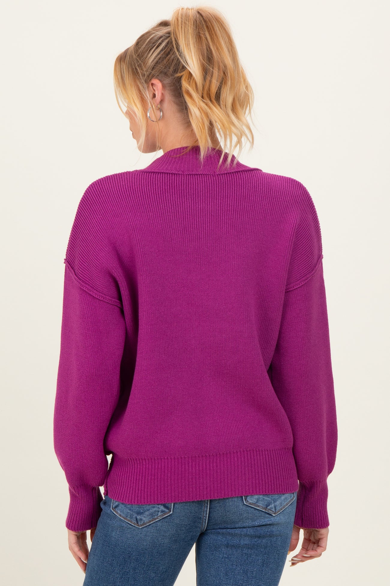 woman wearing a magenta maternity sweater with a relaxed fit and balloon sleeves, showing the back view