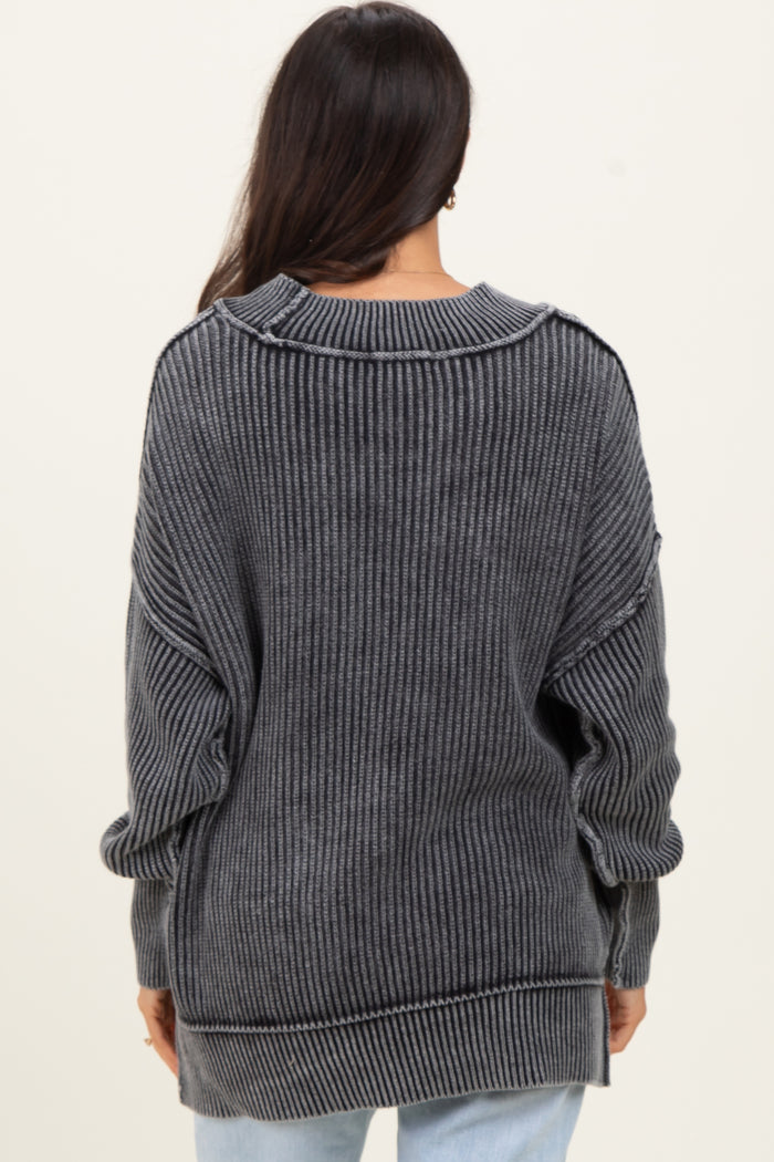 woman wearing a dark gray oversized ribbed sweater with long sleeves and a relaxed fit, viewed from the back