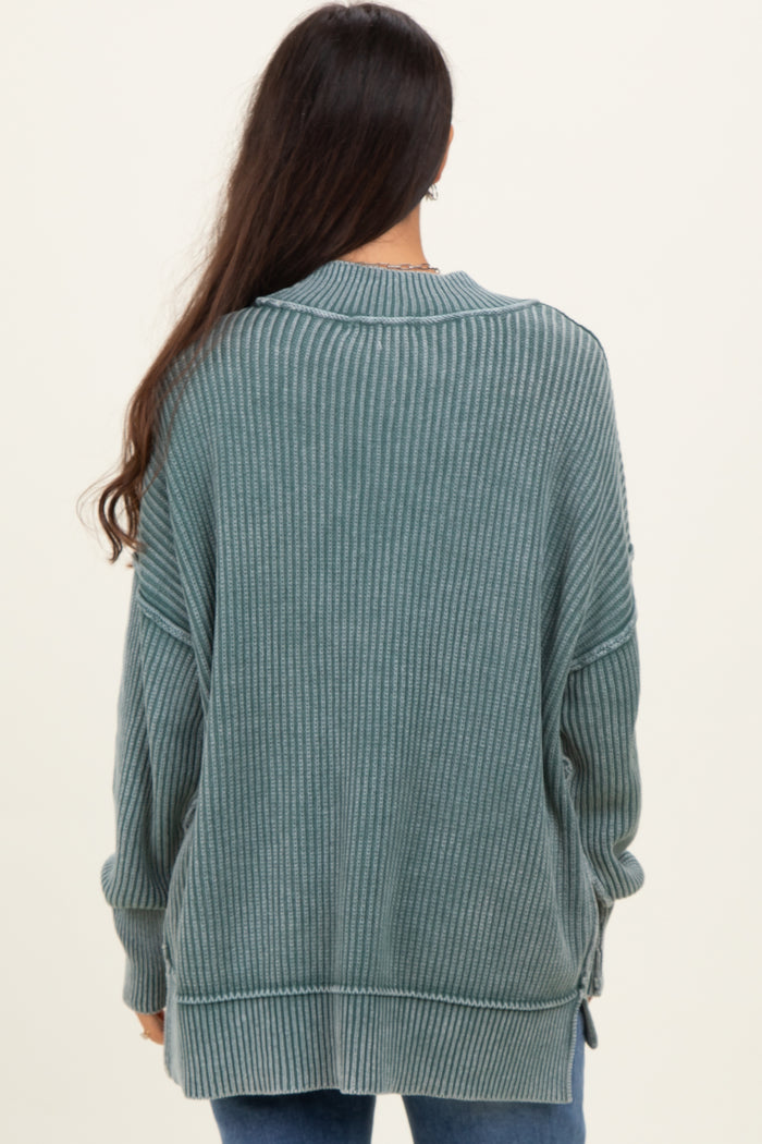 woman wearing a dark teal ribbed long sleeve oversized sweater with side slits and a relaxed fit