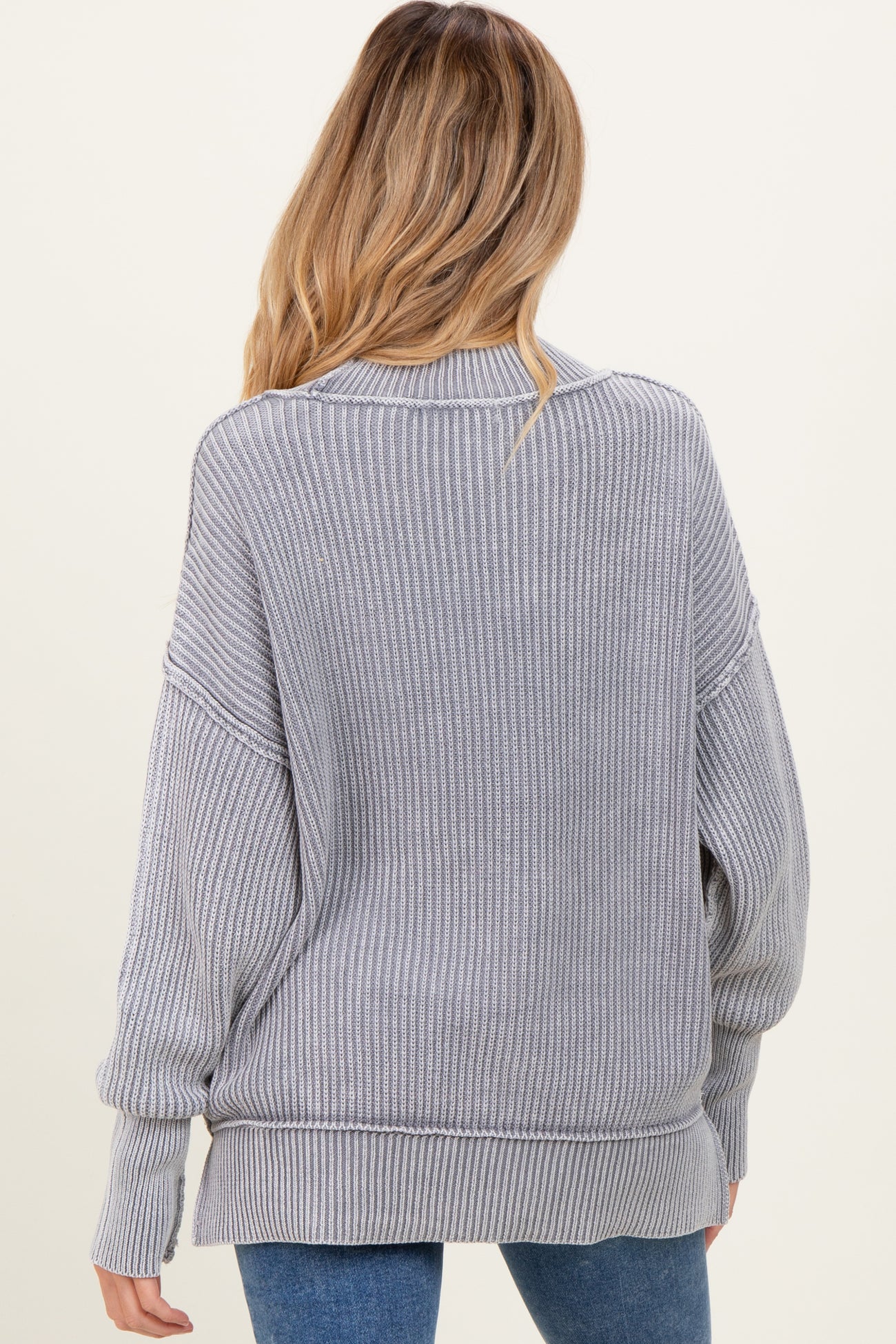 woman wearing a gray ribbed oversized maternity sweater, view from the back