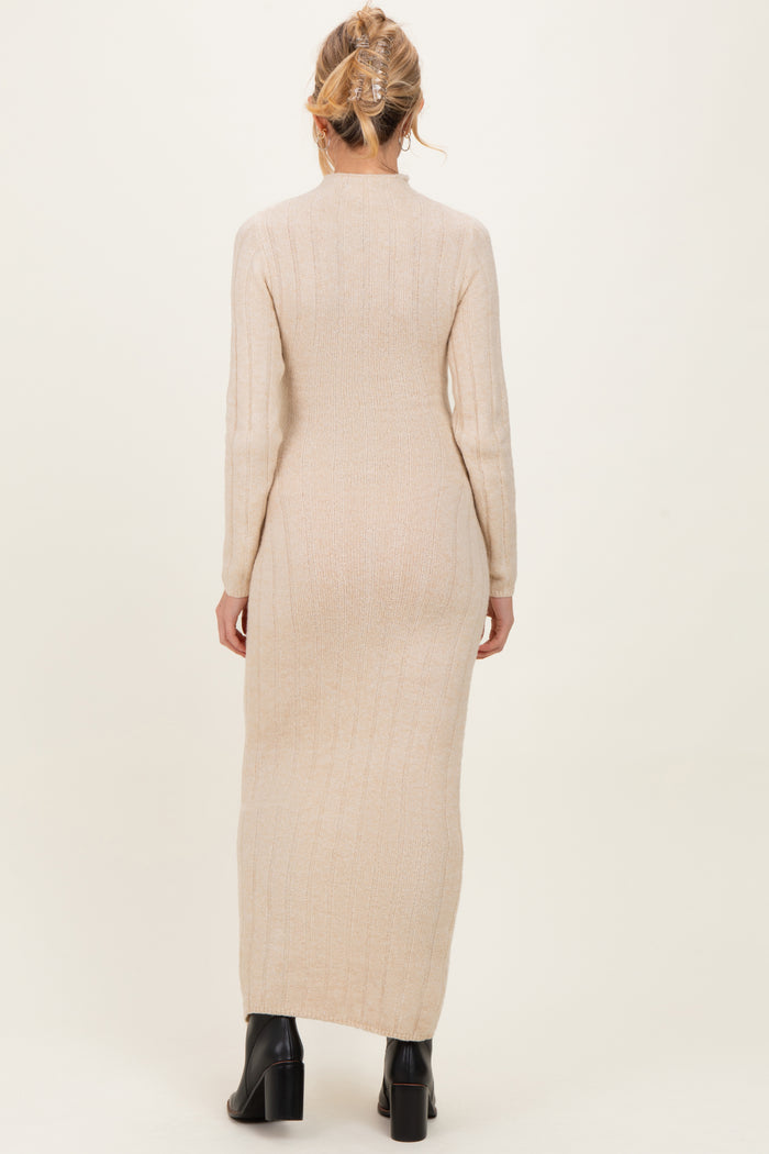 woman wearing a beige long sleeve ribbed maternity dress with a form-fitting silhouette and side slits