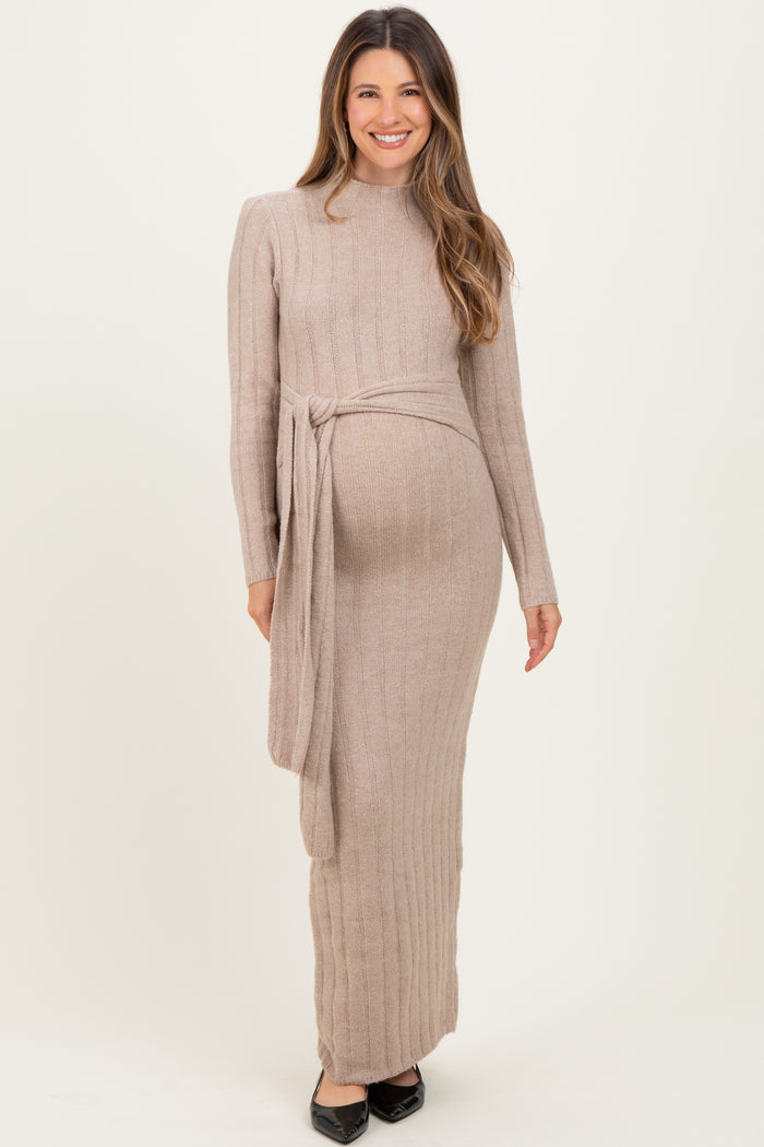 woman wearing a beige long sleeve ribbed maternity dress with a tie at the waist and a visible baby bump