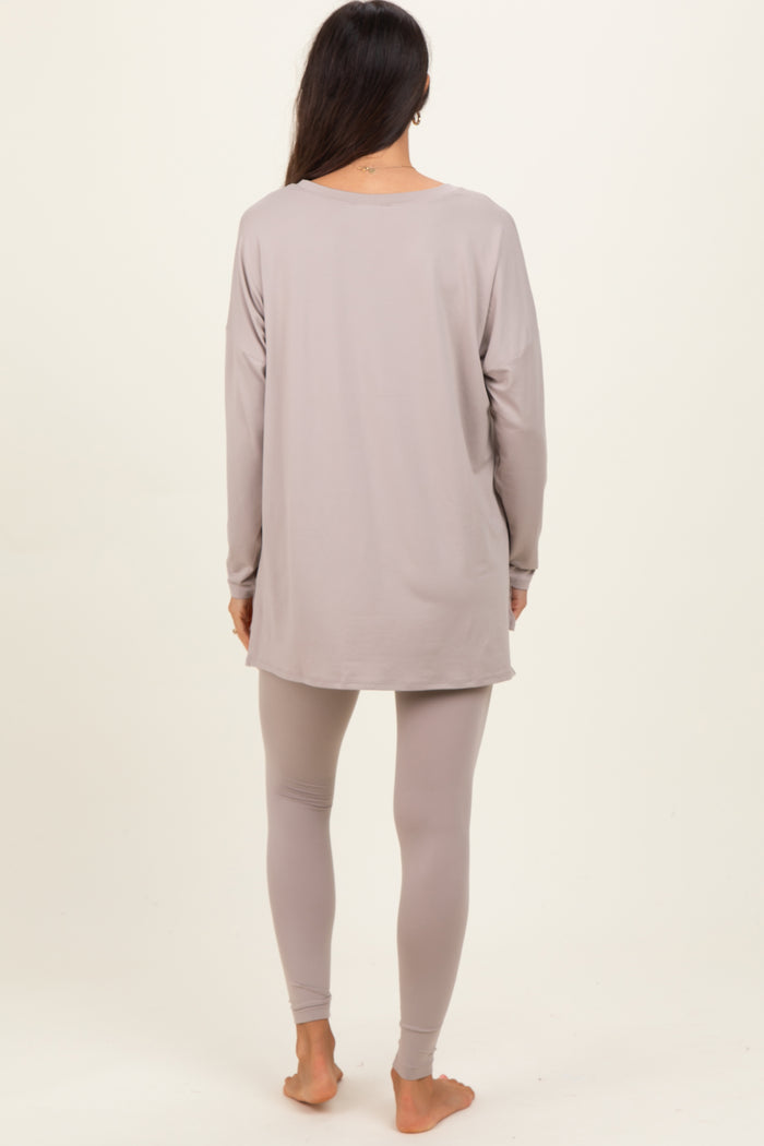 woman wearing a light gray long sleeve top and matching leggings, viewed from the back