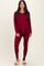woman wearing a burgundy long sleeve top and matching leggings with cozy slippers on her feet