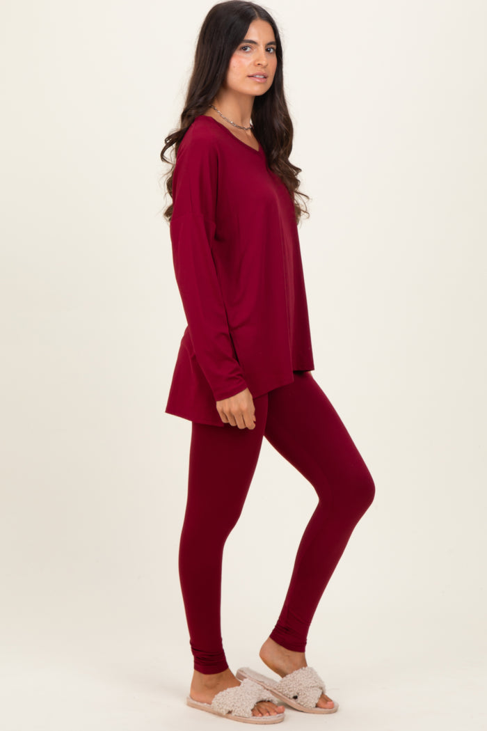 woman wearing a burgundy long sleeve top and matching leggings, styled with cozy slippers