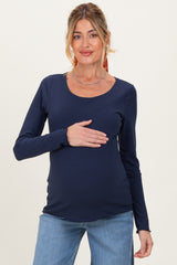 woman wearing a navy long sleeve maternity top and holding her baby bump