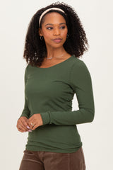 woman wearing a dark green ribbed long sleeve top, styled with a headband and silver jewelry