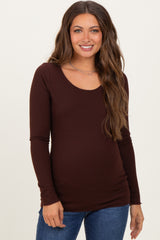 woman wearing a brown long sleeve maternity top with a scoop neckline and a visible baby bump