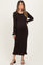 woman wearing a dark brown long sleeve maternity dress with ruffled hem and cuffs, showing her baby bump