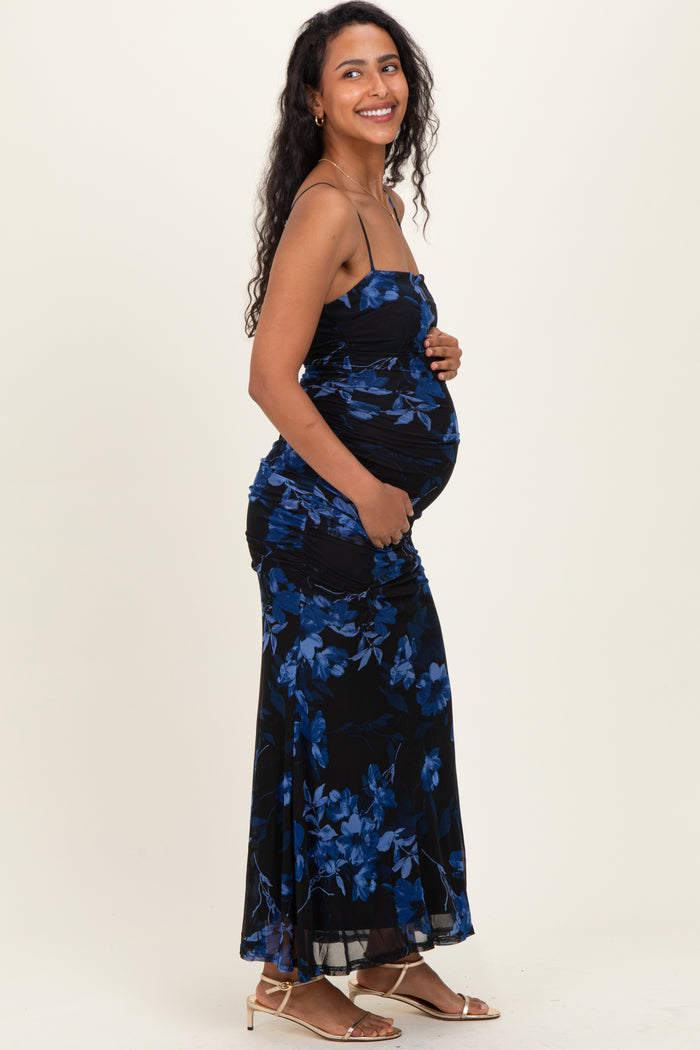 woman wearing a black floral maternity dress and holding her baby bump