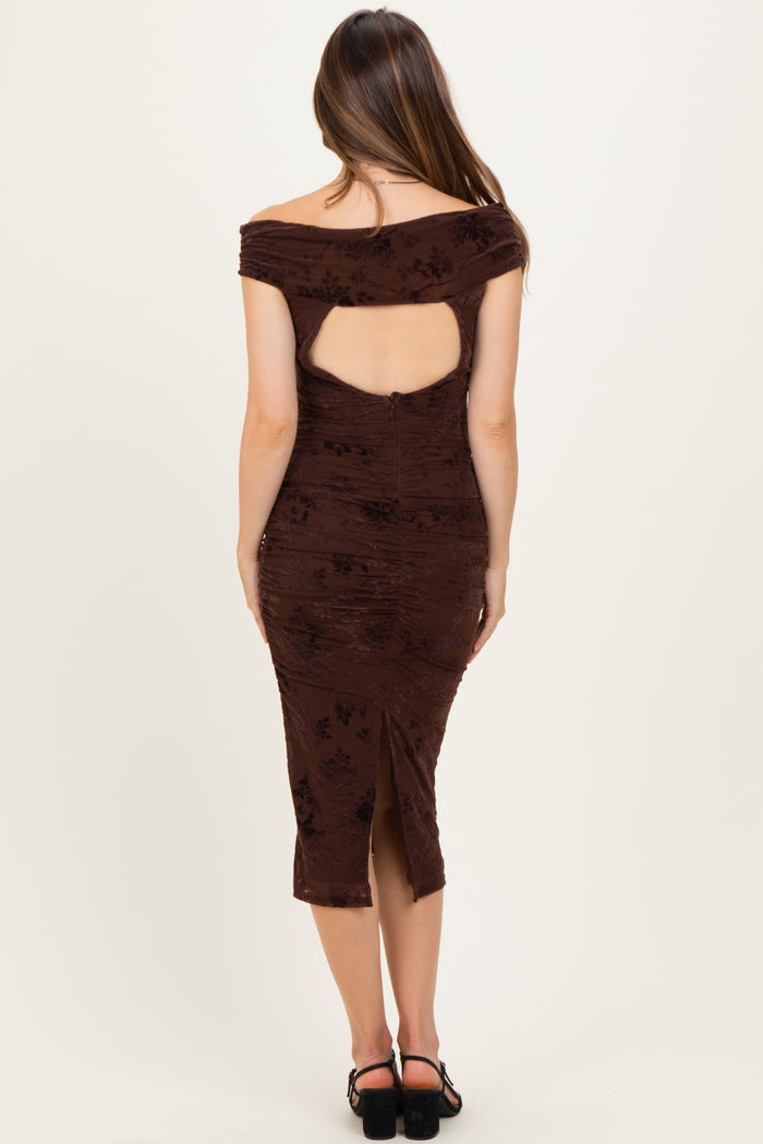 woman wearing a brown maternity dress with off-the-shoulder design and open back details, showing a fitted silhouette