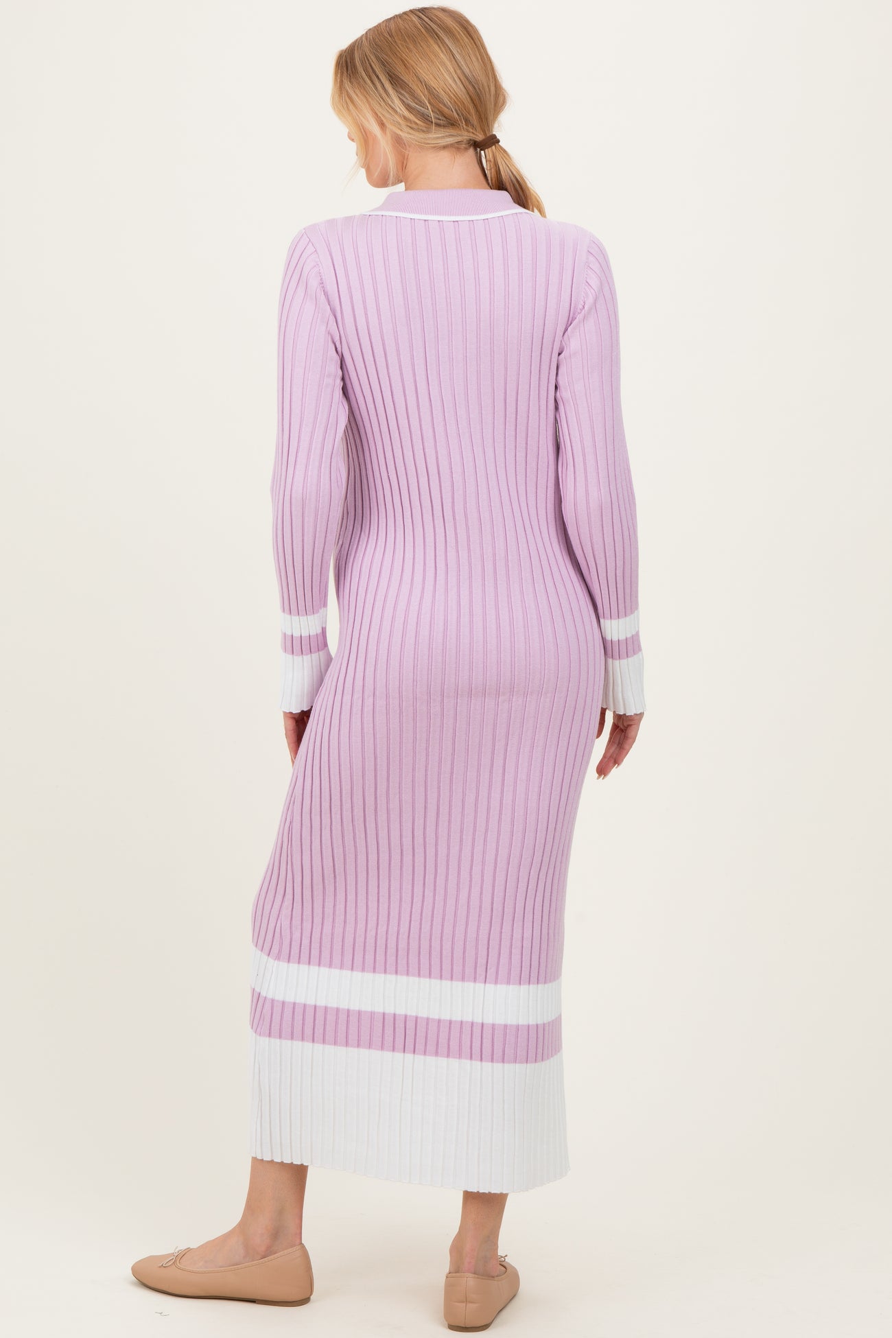 woman wearing a light purple ribbed maternity dress with white stripes and a form-fitting silhouette