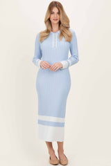 woman wearing a light blue ribbed midi dress with long sleeves and button details at the neckline