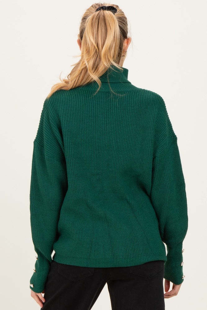 maternity wear in dark green ribbed sweater with a high neck and oversized fit, features button details on sleeves