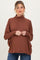 woman wearing a rust colored maternity top with a high neckline and relaxed fit, showcasing her baby bump
