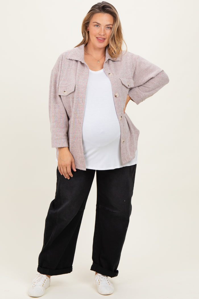 woman wearing a light pink maternity plus oversized button-up jacket over a white tank top and black baggy pants with a baby bump visible