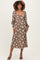 woman wearing a brown floral maternity dress with long sleeves and a v-neckline, showcasing a baby bump