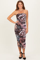 woman wearing a strapless midi dress with a floral print and ruching detail, styled with black heels