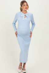 woman wearing a light blue ribbed maternity dress with long sleeves and a bow tie detail, showing her baby bump
